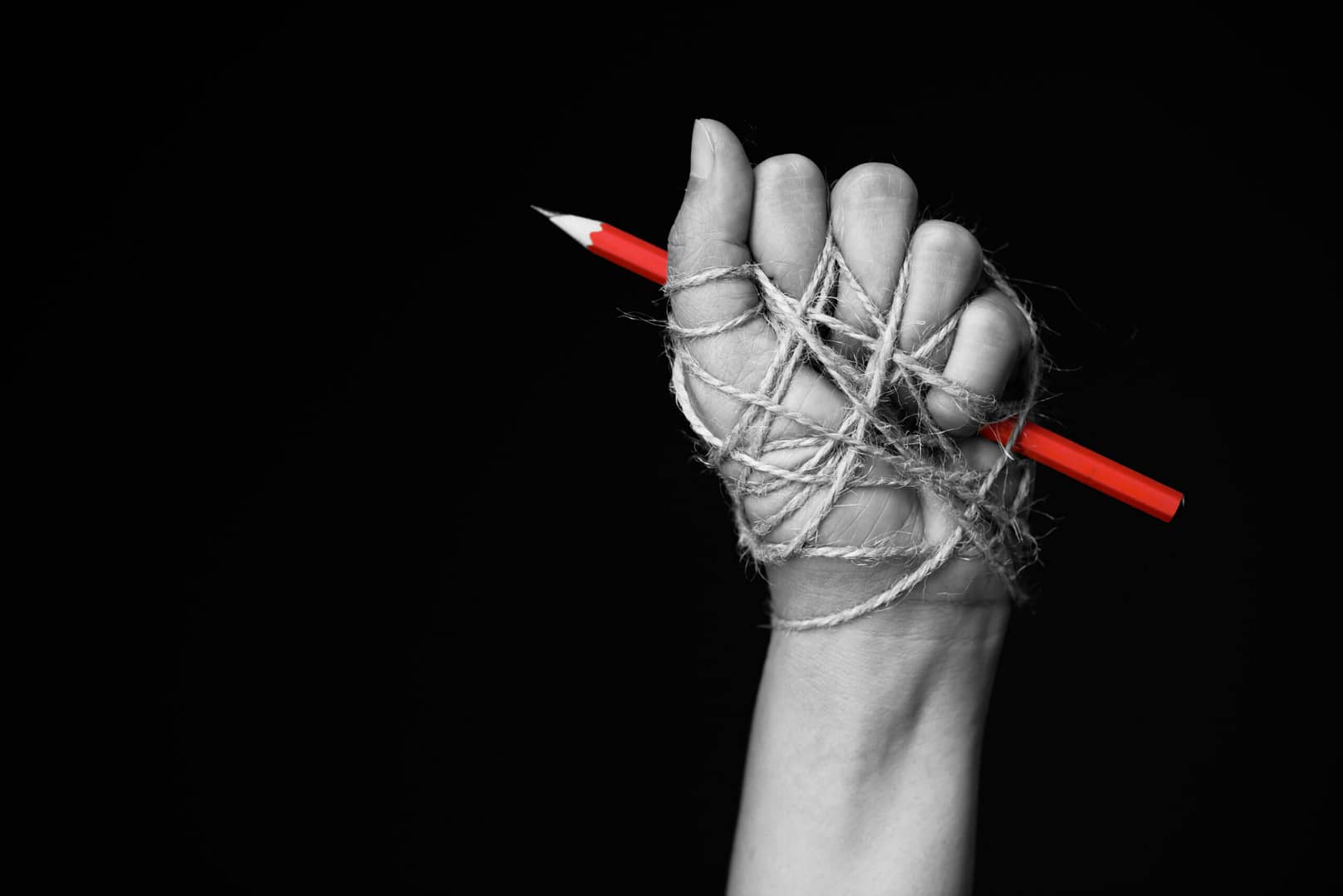 Hand,With,Red,Pencil,Tied,With,Rope,,Depicting,The,Idea