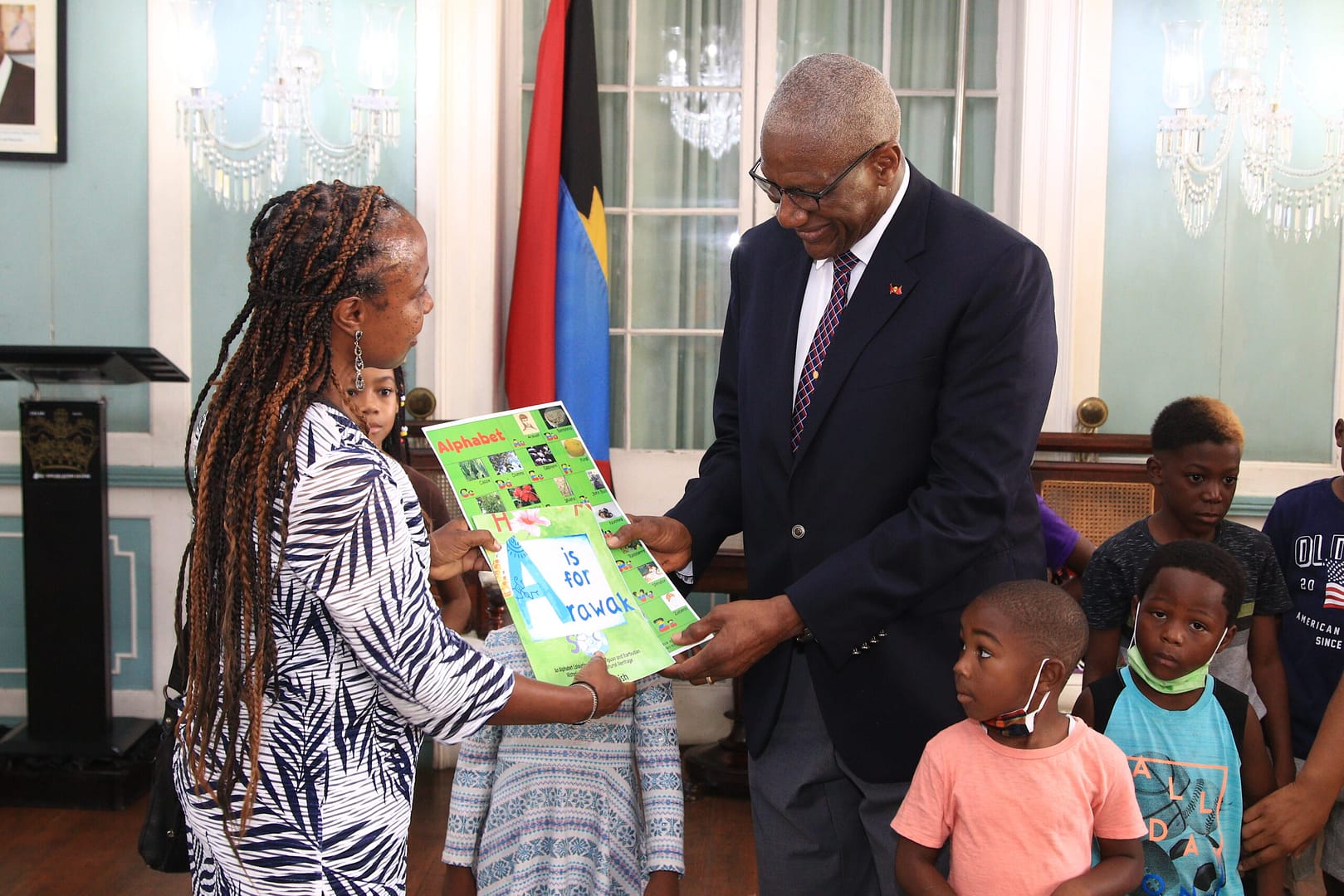 IMG_8539 Mrs Margaret Irish presenting alphabet chart and book for Antiguans and Barbudans to the Governor General with Silston Library Summer School Participants