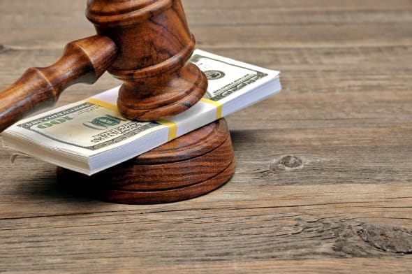 Wad of Money and Judges Gavel on Wooden Table